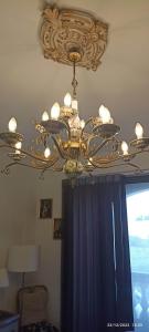 a chandelier hanging from a ceiling in a room at Close to airport, double bedroom, sofa-bed, private bathroom for adults and children aged 10 and over ONLY in Gudja