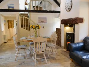 a dining room and living room with a table and chairs at Whatley Lodge in Winsham