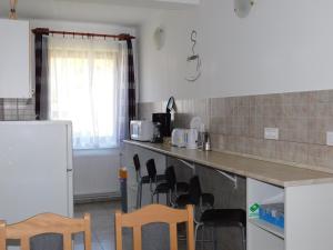 a kitchen with a counter and chairs in it at 8888 Vendégház in Lispeszentadorján