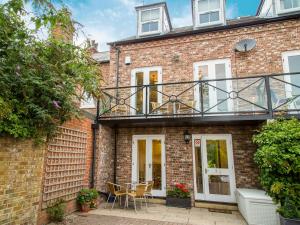 a brick house with a balcony with a table and chairs at Abbeygate House in York