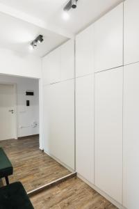 a room with white cabinets and a green chair at Skylark - Zurich Studio with Terrace & Mountain view in Braşov