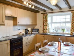 a kitchen with a table and a stove top oven at Riverview in Frosterley