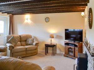 a living room with a couch and a flat screen tv at Riverview in Frosterley