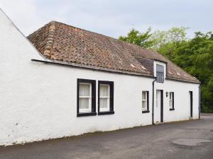 un bâtiment blanc avec des fenêtres noires et un toit dans l'établissement Inn Cottage, à Glendevon