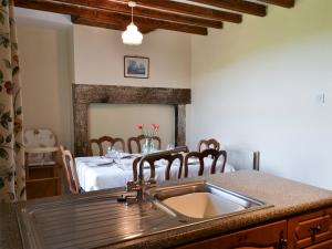 a kitchen with a sink and a dining table at East Bridge End Farm in Frosterley