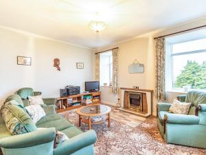 a living room with two couches and a fireplace at Catch A Penny in Burnmouth