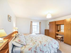 a bedroom with a bed and a desk and a window at Catch A Penny in Burnmouth