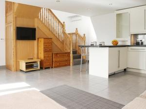 a kitchen with a counter top and a staircase at Chestnut Cottage in Knitsley
