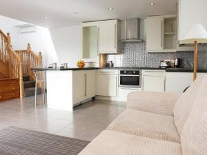 een keuken met witte kasten en een fornuis met oven bij Chestnut Cottage in Knitsley