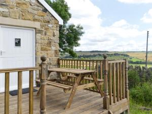 a wooden deck with a table and a garage at Chestnut Cottage in Knitsley