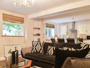 a living room with a black couch and a chandelier at Barn Terrace - 28972 in Selstead