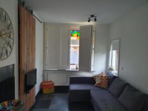 ein Wohnzimmer mit einem Sofa und einem Fenster in der Unterkunft B&B de Loeff in Waalwijk