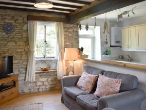 a living room with a couch and a kitchen at Herston Rise in Swanage