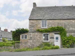 an old stone house with a white door at Herston Rise in Swanage