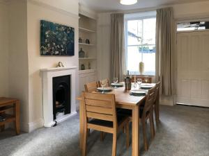 a dining room with a table and chairs and a fireplace at Ivy Cottage in Skipton