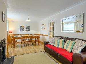 a living room with a couch and a dining room at Leeward Cottage in Wells next the Sea