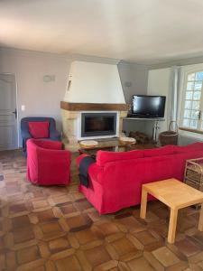 sala de estar con 2 sofás rojos y chimenea en Foix Villa 150m2 dans très grand parc arboré en Foix