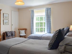 um quarto com 2 camas e uma janela em Laundry Cottage em Rudston