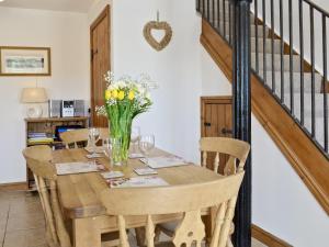 uma sala de jantar com uma mesa de madeira com flores em Copper House - 18435 em Bempton