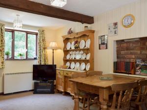 a living room with a table and a tv at The Shippon in Burscough