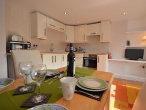 a kitchen with a table with glasses and a bottle of wine at Platform One in Paignton