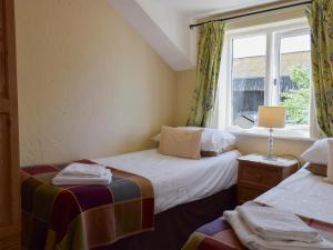 two beds in a small room with a window at The Shippon in Burscough