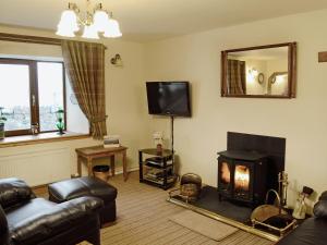 a living room with a fireplace and a television at Ben View in Gairloch