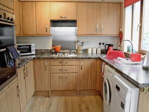 a kitchen with wooden cabinets and a white appliance at Ben View in Gairloch
