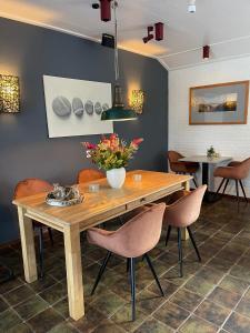 - une salle à manger avec une table et des chaises en bois dans l'établissement DuinHotel Texel, à De Koog