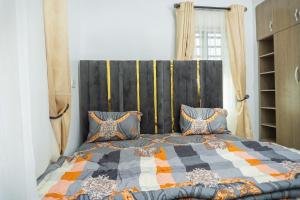 a bedroom with a large bed with blue pillows at Spectacular 3/4-Bed-Apt With 24hrs Power And FAST Wi-Fi in Amuwo