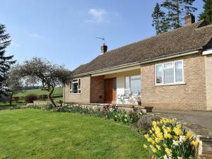 a brick house with a lawn in front of it at Roundhill in Eydon