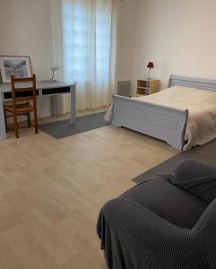 1 dormitorio con escritorio, 1 cama y 1 mesa en Foix Villa 150m2 dans très grand parc arboré en Foix