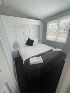 a bedroom with a large bed with a black blanket at The Winchester Chalet by Sasco in Blackpool