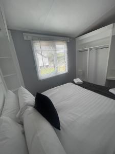a bedroom with a large white bed and a window at The Winchester Chalet by Sasco in Blackpool