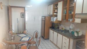 a small kitchen with a table and a refrigerator at Espaço ALA Minas in São Lourenço