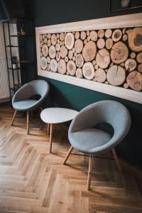 una habitación con 2 sillas y una pared con troncos en Płazowianka en Witów
