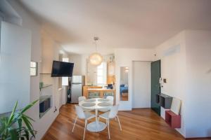 un soggiorno con tavolo e sedie e una cucina di Torretta10 - Studio Apartment a Trieste