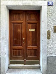 una puerta de madera en un edificio con una señal encima en Torretta10 - Studio Apartment, en Trieste
