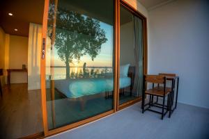 een slaapkamer met uitzicht op een bed en een raam bij LAKE HOUSE Naka Cave in Ban Don Klang