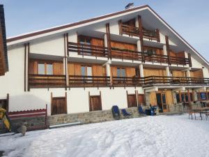 een gebouw in de sneeuw met stoelen ervoor bij BAITA DEL SOLE in Teglio