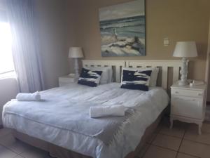 a bedroom with a large white bed with blue pillows at Bluewater Beachfront Guest House in Port Elizabeth +32 photos