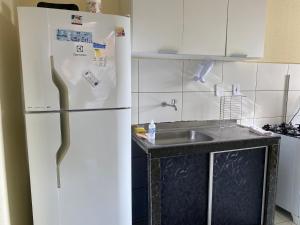 een keuken met een witte koelkast en een wastafel bij Vog João de Góes in Ilhéus