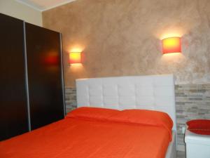 - une chambre avec un lit avec des draps orange et deux lumières dans l'établissement Home Marisol, à Augusta