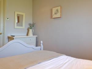 a bedroom with a bed and a dresser and a mirror at 3 Gill Edge Cottages in Countersett
