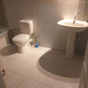 La salle de bains blanche est pourvue de toilettes et d'un lavabo. dans l'établissement Mourad House, à Assouan