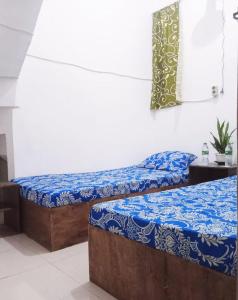 two beds in a room with blue and white sheets at GreenKOST in Sintang