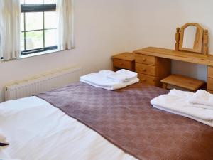 um quarto com duas toalhas brancas numa cama em Horseshoe Cottage -31299 em Holywell Bay