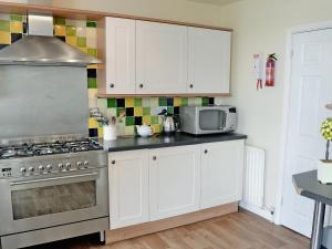 a kitchen with a stove and a microwave at Waterside in Bowness-on-Windermere