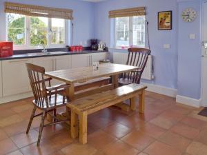 cocina con mesa de madera y 2 sillas en Granary Cottage en Bentley