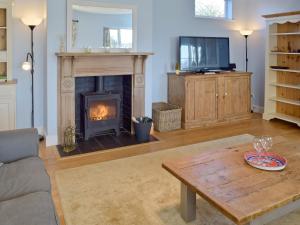 a living room with a fireplace and a coffee table at Granary Cottage in Bentley